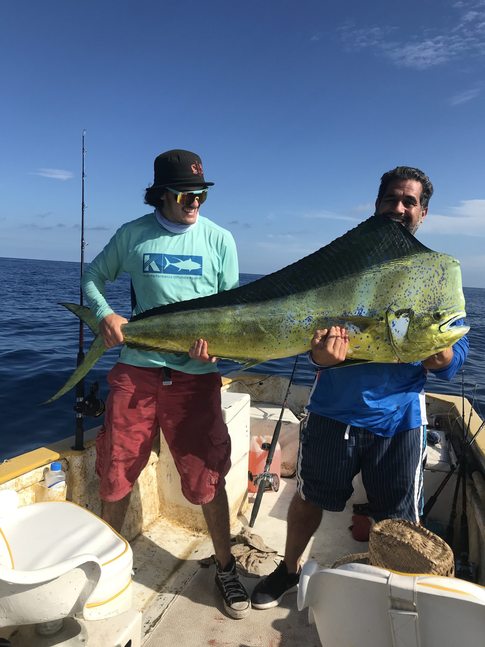 Luis Perez and his father hold a large fish they just caught while deep sea fishing